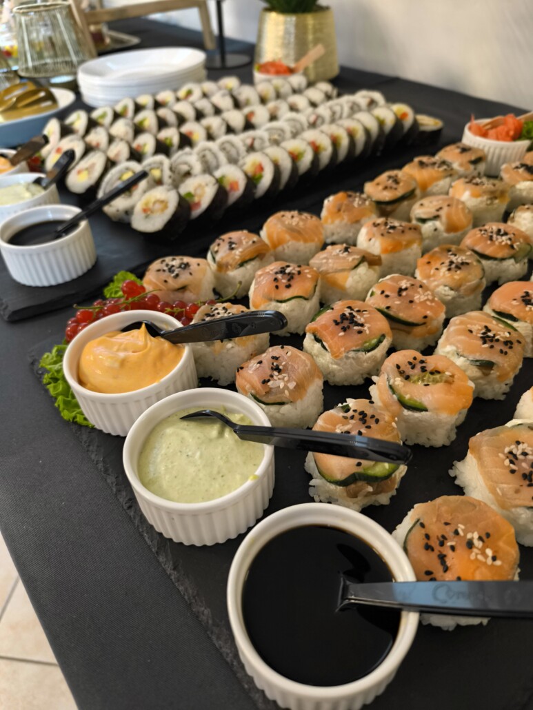Sushi i sosy na czarnym blacie